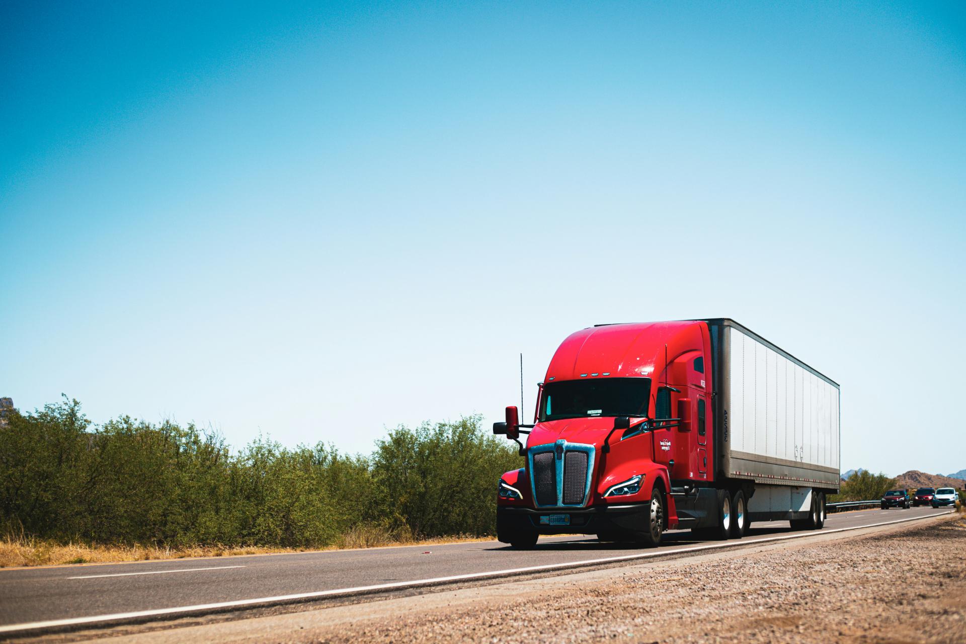 Red truck driving on open highway